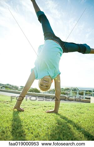 Girl doing cartwheel on grass View Large Photo Image Stock Image - Girl doing cartwheel on grass. Fotosearch