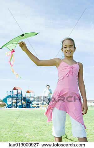 Girl holding up kite View Large Photo Image Stock Photo - Girl holding up kite. Fotosearch