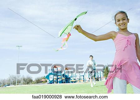 Stock Photo - Girl holding up kite. Fotosearch