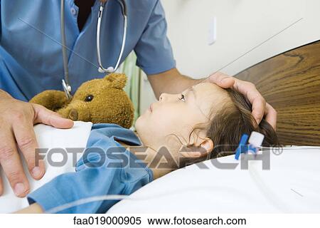 Girl lying in hospital bed, male nurse's hand on girl's head View Large Photo Image Stock Photography - Girl lying in hospital bed, male nurse's hand on girl's head. Fotosearch