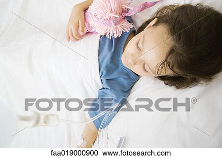 Stock Image - Girl lying in hospital bed. Fotosearch
