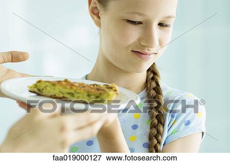 Girl making face at piece of quiche View Large Photo Image Stock Photo - Girl making face at piece of quiche. Fotosearch