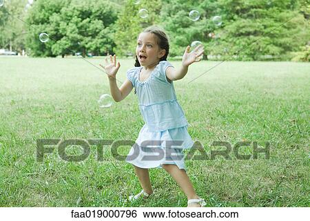 Girl reaching for bubbles View Large Photo Image Stock Photograph - Girl reaching for bubbles. Fotosearch