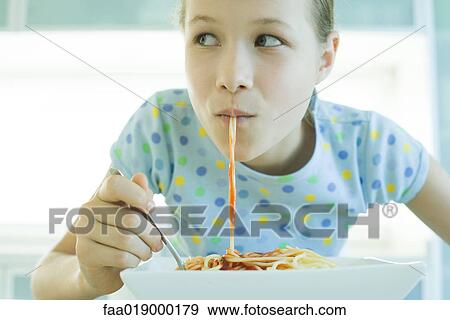 Girl slurping spaghetti noodles View Large Photo Image Stock Photo - Girl slurping spaghetti noodles. Fotosearch