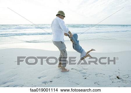 Grandfather swinging boy on beach View Large Photo Image Picture - Grandfather swinging boy on beach. Fotosearch