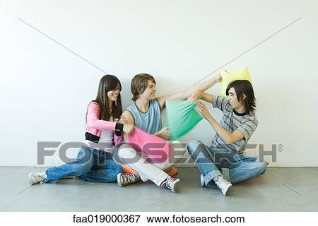 Group of young friends having pillow fight View Large Photo Image Stock Photo - Group of young friends having pillow fight. Fotosearch