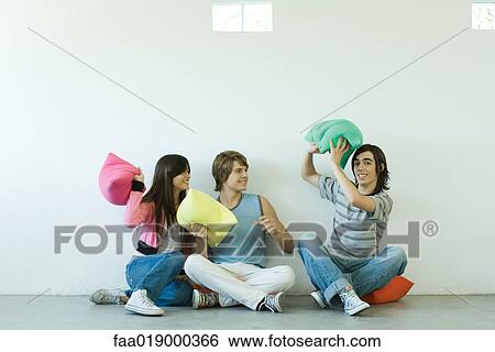 Group of young friends having pillow fight View Large Photo Image Stock Photograph - Group of young friends having pillow fight. Fotosearch