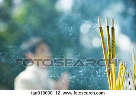 Incense burning, man in blurred background View Large Photo Image Stock Image - Incense burning, man in blurred background. Fotosearch