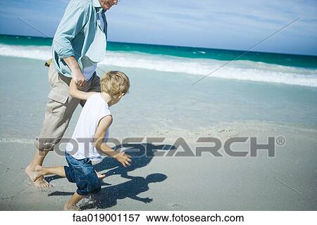 Man and boy walking on beach View Large Photo Image Stock Photo - Man and boy walking on beach. Fotosearch