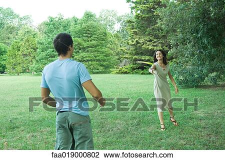 Man and woman playing with plastic disc View Large Photo Image Stock Image - Man and woman playing with plastic disc . Fotosearch