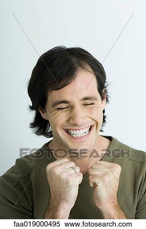 Man, closing eyes, smiling and holding up fists, portrait View Large Photo Image Stock Photography - Man, closing eyes, smiling and holding up fists, portrait. Fotosearch
