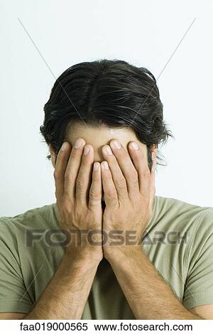 Stock Photography - Man covering face with hands, portrait. Fotosearch