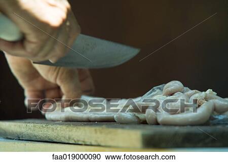Stock Image - Man cutting meat, close-up. Fotosearch
