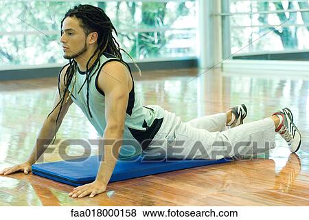 Stock Photo - Man doing cobra pose, full length. Fotosearch