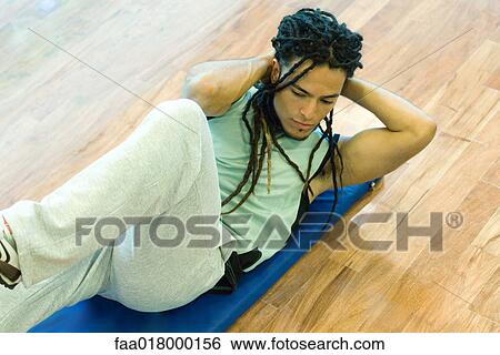 Stock Photograph - Man doing sit-ups. Fotosearch