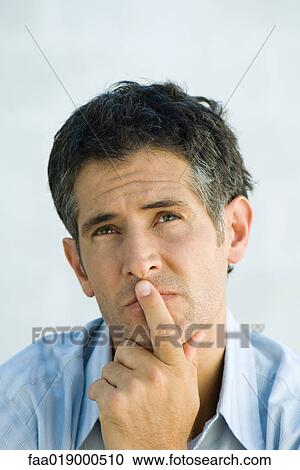 Man, finger over lips, looking up, portrait View Large Photo Image Stock Image - Man, finger over lips, looking up, portrait. Fotosearch
