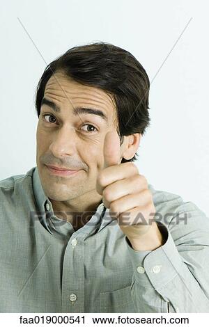 Stock Image - Man giving thumbs up sign, portrait. Fotosearch