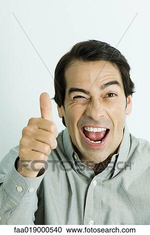 Man giving thumbs up sign, winking, portrait View Large Photo Image Stock Image - Man giving thumbs up sign, winking, portrait. Fotosearch