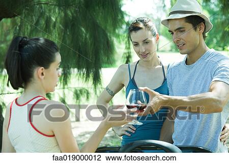 Man handing teen girl glass of wine during cookout View Large Photo Image Stock Image - Man handing teen girl glass of wine during cookout. Fotosearch