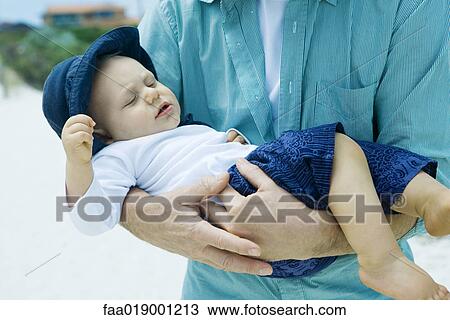 Man holding baby on beach View Large Photo Image Stock Image - Man holding baby on beach. Fotosearch
