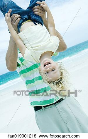 Man holding child upside down on beach View Large Photo Image Stock Photo - Man holding child upside down on beach. Fotosearch