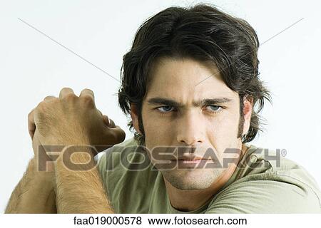 Man holding up clasped hands, furrowing brow, portrait View Large Photo Image Stock Photo - Man holding up clasped hands, furrowing brow, portrait. Fotosearch