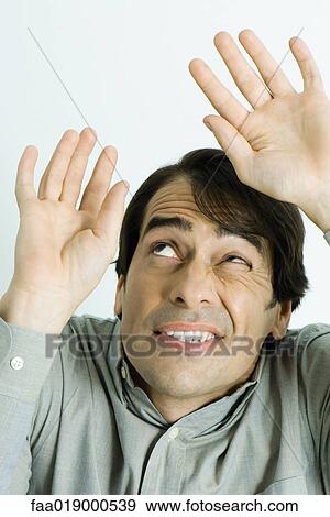 Man holding up hands protectively, looking up, portrait View Large Photo Image Stock Photo - Man holding up hands protectively, looking up, portrait. Fotosearch