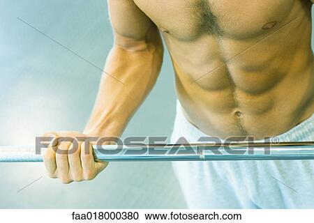 Man lifting barbell, close-up of mid section View Large Photo Image Stock Image - Man lifting barbell, close-up of mid section. Fotosearch