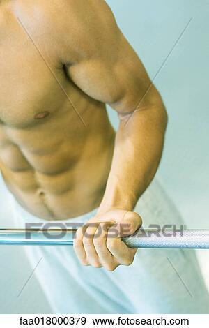 Stock Photo - Man lifting barbell, close-up of mid section. Fotosearch