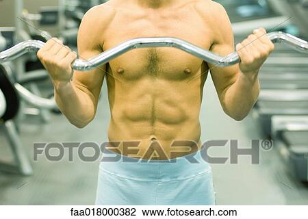 Man lifting barbell, close-up of torso View Large Photo Image Stock Image - Man lifting barbell, close-up of torso. Fotosearch