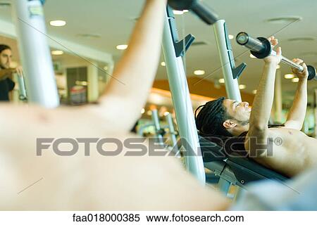 Man lifting barbell, reflected in mirror View Large Photo Image Stock Photography - Man lifting barbell, reflected in mirror. Fotosearch