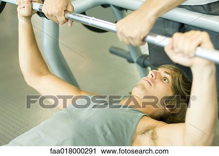 Man lifting barbell while second man spots View Large Photo Image Stock Image - Man lifting barbell while second man spots. Fotosearch