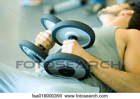 Man lying on back, holding weights on stomach View Large Photo Image Stock Photo - Man lying on back, holding weights on stomach. Fotosearch
