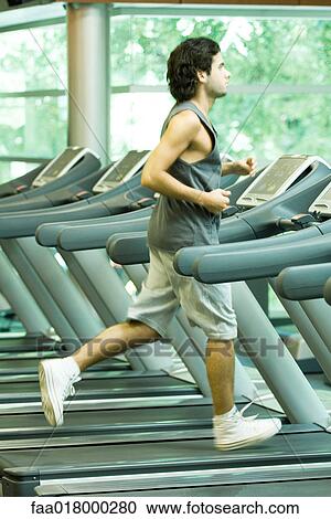 Stock Image - Man running on treadmill. Fotosearch