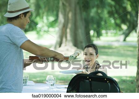 Man serving woman kebab during cookout View Large Photo Image Picture - Man serving woman kebab during cookout. Fotosearch