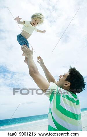 Man throwing child into air on beach View Large Photo Image Stock Photography - Man throwing child into air on beach. Fotosearch