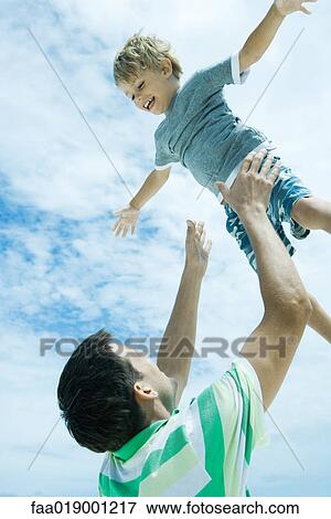 Man throwing child into air View Large Photo Image Stock Photo - Man throwing child into air. Fotosearch