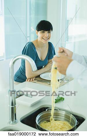 Man tossing spaghetti over kitchen sink while woman watches View Large Photo Image Stock Image - Man tossing spaghetti over kitchen sink while woman watches. Fotosearch