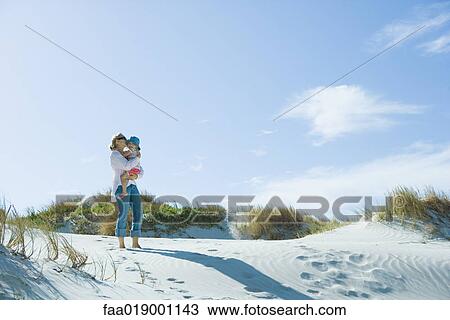 Mother and daughter standing on dune View Large Photo Image Stock Image - Mother and daughter standing on dune. Fotosearch