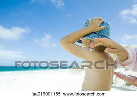 Mother putting sunscreen on child at beach View Large Photo Image Stock Photography - Mother putting sunscreen on child at beach. Fotosearch