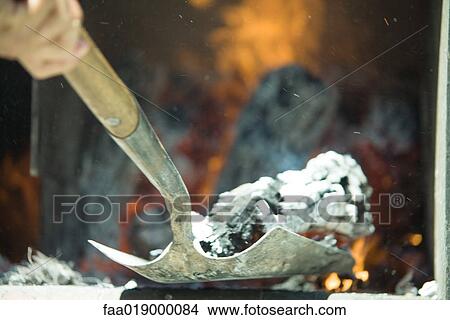 Person shoveling ashes in wood oven View Large Photo Image Picture - Person shoveling ashes in wood oven . Fotosearch