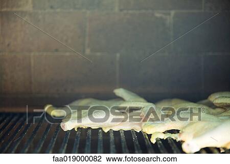 Poultry grilling in wood oven View Large Photo Image Stock Image - Poultry grilling in wood oven. Fotosearch