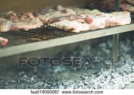 Slabs of meat cooking on barbecue View Large Photo Image Stock Photo - Slabs of meat cooking on barbecue. Fotosearch