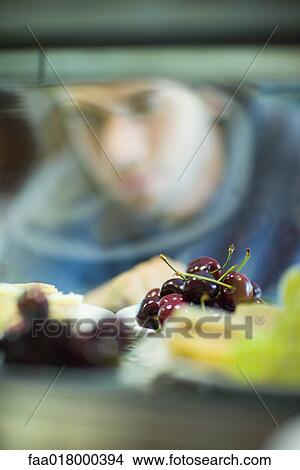 Picture - Snack bar, man in blurred background looking at choices. Fotosearch