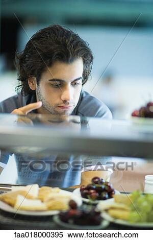 Stock Photography - Snack bar, man looking at choices. Fotosearch