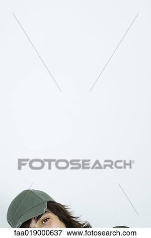 Stock Photo - Teen boy wearing cap, looking at camera, partial view of head. Fotosearch