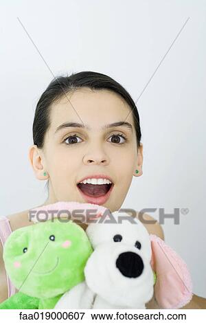 Stock Photo - Teen girl holding stuffed animals, portrait. Fotosearch