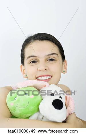 Stock Photo - Teen girl holding stuffed animals, portrait. Fotosearch