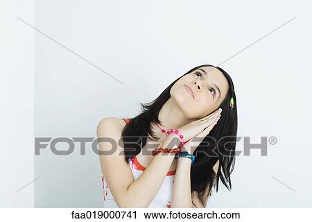 Teen girl leaning head on clasped hands, looking up, portrait View Large Photo Image Stock Image - Teen girl leaning head on clasped hands, looking up, portrait. Fotosearch