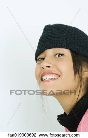 Stock Image - Teen girl wearing knit hat, portrait. Fotosearch